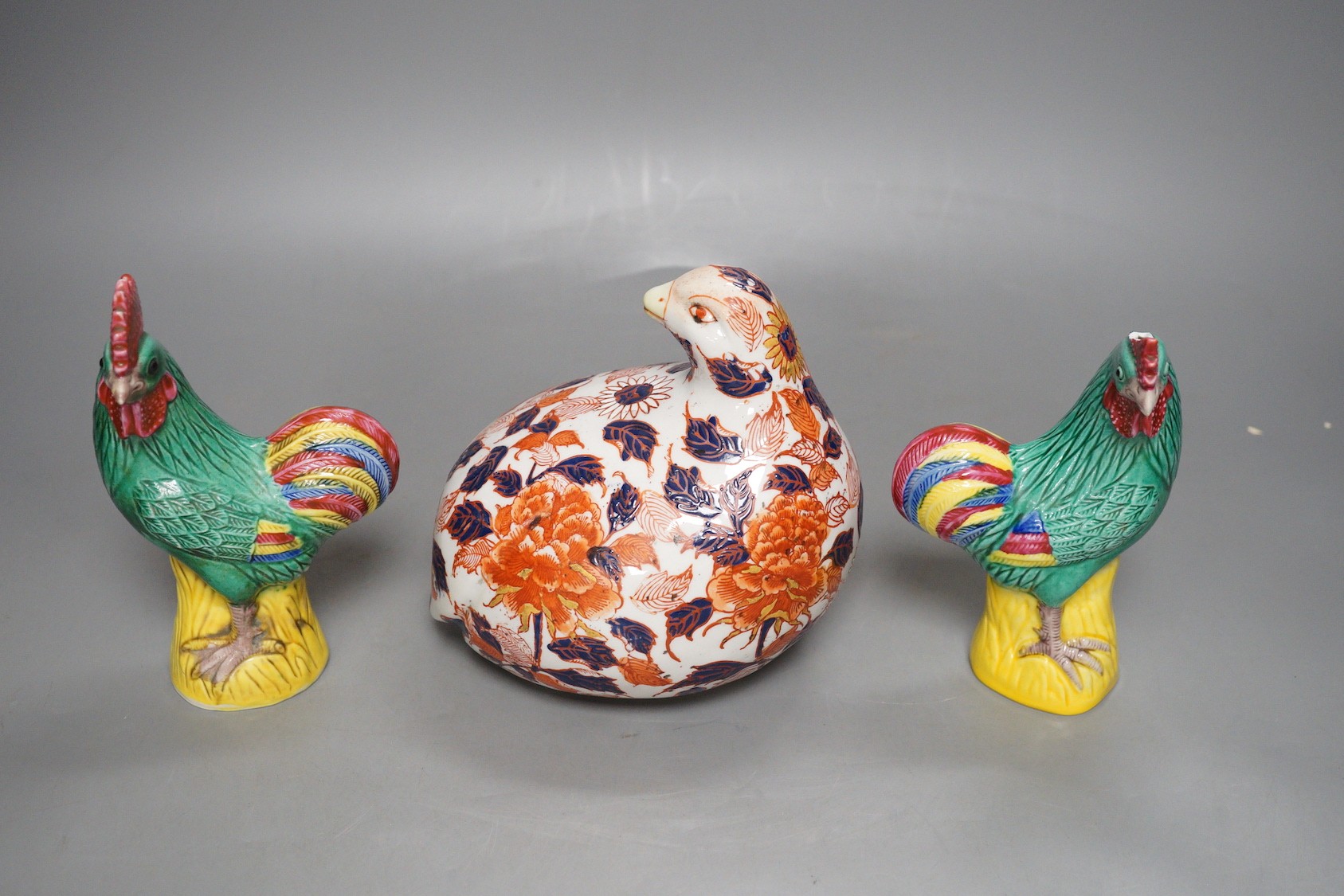 A pair of Chinese pottery roosters and an Imari quail, tallest 15cm